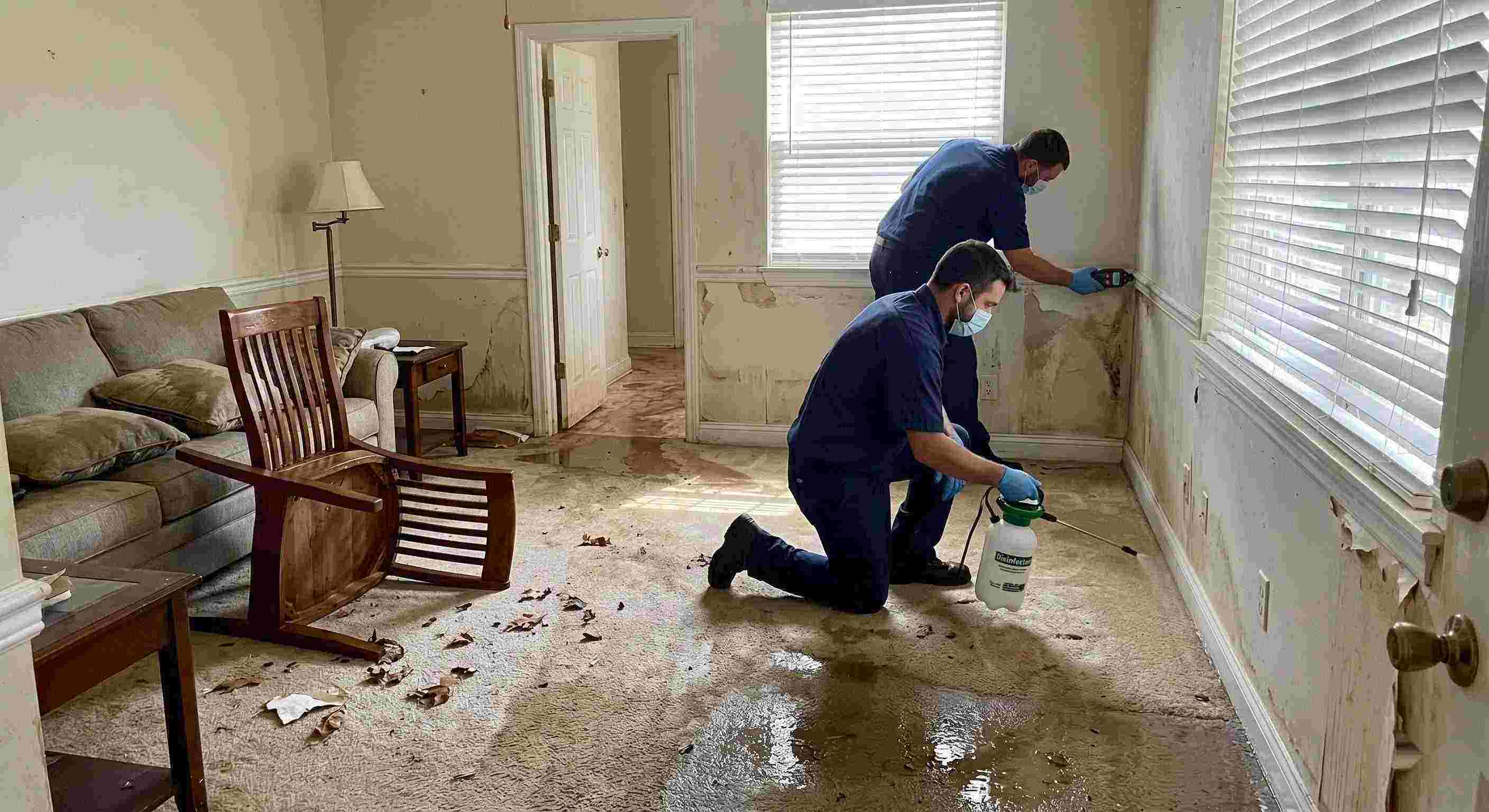 Fast technicians performing flood disinfection after water damage inside a home in Kettering, ensuring wet floors, damp walls, and household items are sanitized safely.